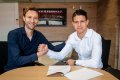 Adam Hložek se sportovním ředitelem a bývalým záložníkem Leverkusenu Simonem Roflesem při podpisu smlouvy, která jej s Bayerem spojila do června 2027. Foto: bayer04.de